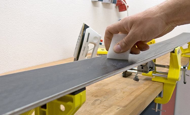 Farter ses ski avec la cire chaude L'homme applique du fart chaud sur les skis.