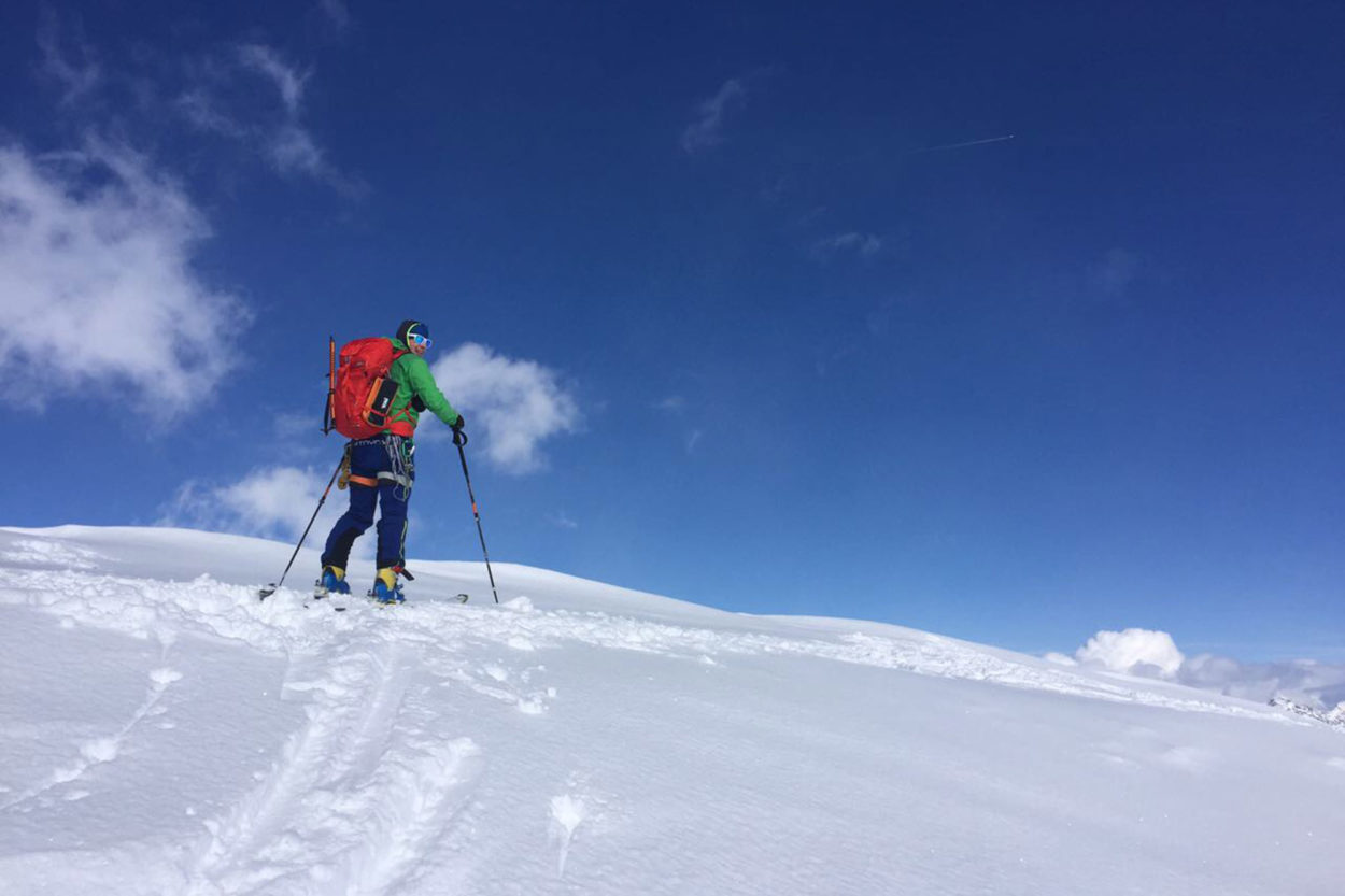 Mann mit Skitourenrucksack beim Aufstieg