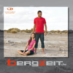 Eine Frau und ein Mann in kurzer Sommer-Freizeitkleidung in karger W&uuml;stenlandschaft - Katalog-Cover mit Bergzeit Logo