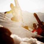 Zwei Bergsteiger mit Ski am R&uuml;cken steigen mit Pickel einen schneebedeckten Hang hinauf