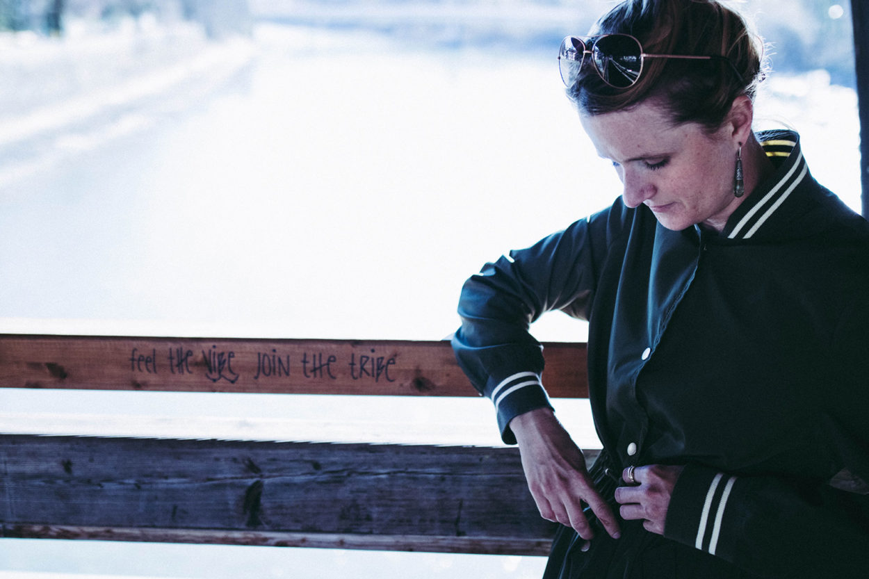 Frau lehnt an Brückenbrüstung in LangerChen Mantel