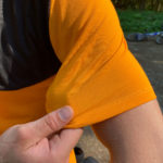 Mountainbiker greift den Stoff seines Trikots am Ärmel