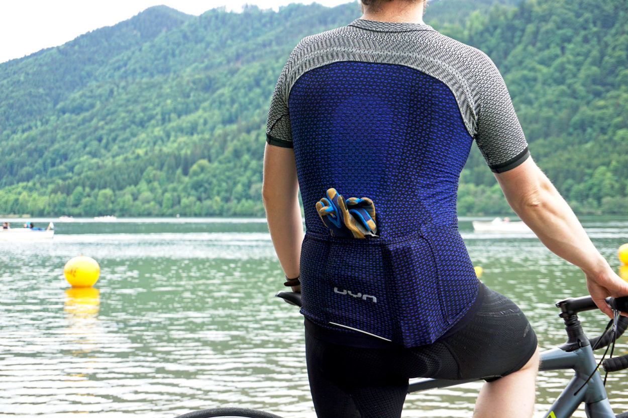 Radfahrer von hinten blickt auf den See