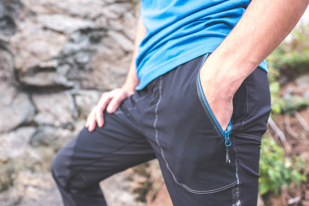 Eine Hand in der Reißverschluss-Hosentasche der Montura Vertigo Light Hose.