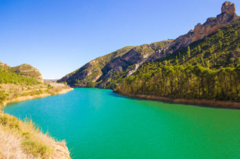Türkisblauer Fluss mit bewaldeten Hängen