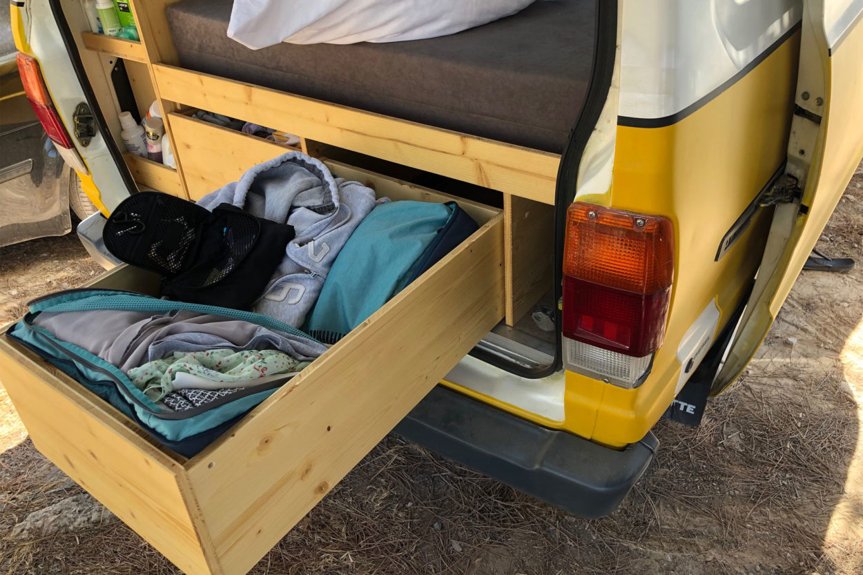 Eine ausgezogene Schublade in einem Campervan mit dem gefalteten Deuter Aviant Rucksack drin.