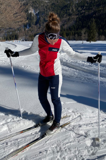 Langläuferin neben der Loipe mit Jacke und Hose von Swix
